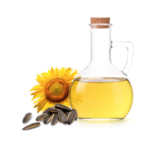 Sunflower seed oil in glass bottle and fresh organic sun flower seeds isolated on white background.